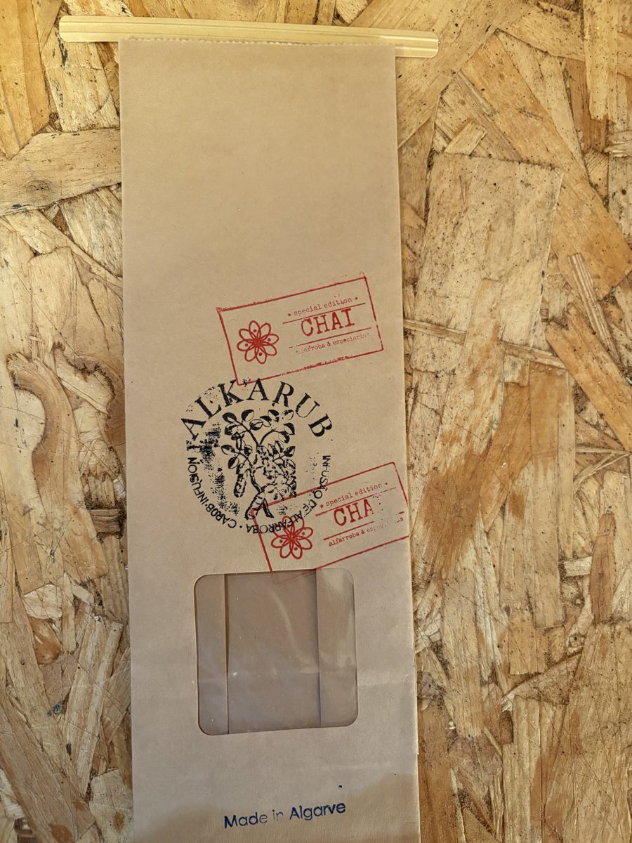 Saco de papel kraft da Alkarub com o carimbo vermelho «special edition Chai, alfarroba e especiarias»
